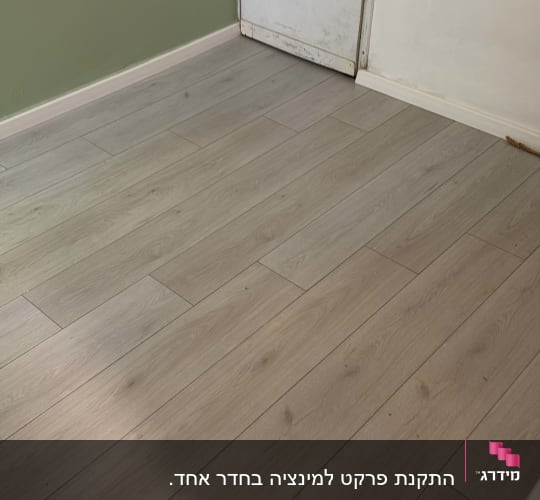 רצפת פרקט עץ בהירה ליד דלת לבנה